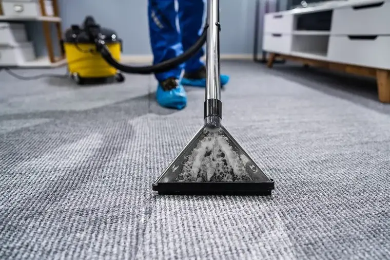Extraction wand pulling water out of wet carpet during a Woodside dry-out