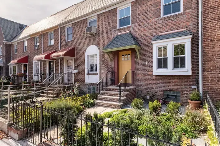 Attached brick houses with stoops on a Woodside, Queens block
