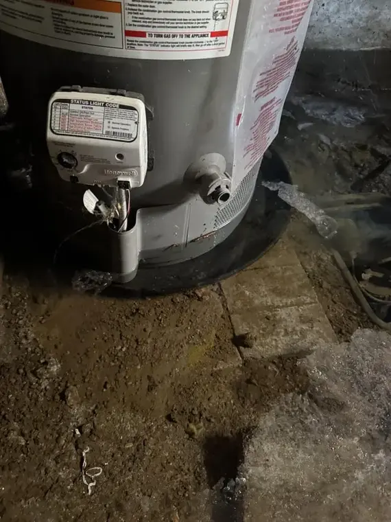 Water heater standing in water on a basement floor in Queens